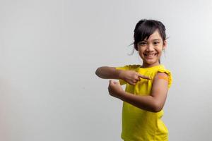 concepto de vacunas covid 19 para niños. estudio un retrato de una adorable niña asiática después de recibir su primera dosis de vacuna. inmune, seguro, disponible, regreso a la escuela. foto