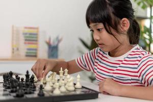 Little boy and little girl are playing chess at home.Children playing chess photo