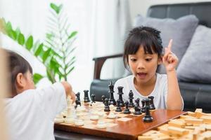 Two cute children playing chess at home photo