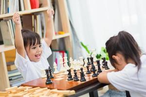 Kids playing chess - one of them just captured a pawn and celebrates photo