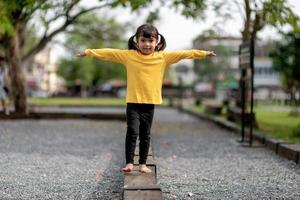 Asian child girl playing on the playground in the outdoor park.Happy moment and good emotion photo