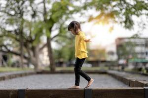 niña asiática jugando en el patio de recreo en el parque al aire libre.momento feliz y buena emoción foto