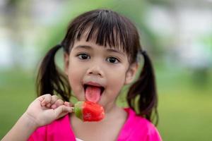 linda niña pequeña comiendo helado foto