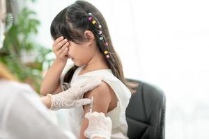 Successful covid-19 vaccination. cute little girl while being immunized against coronavirus photo