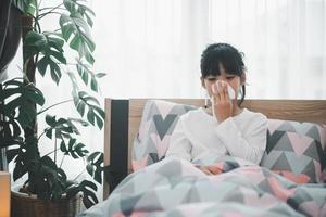 little girl gets cold and blows her nose at home. photo