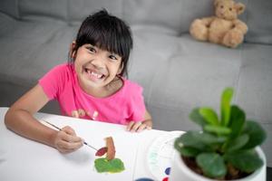 Girl Painting Picture On Table At Home photo