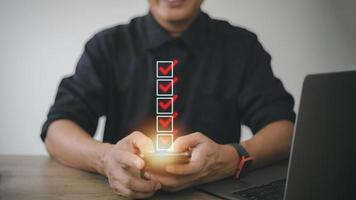 Checklist concept, Businessman checking mark on the check boxes with marker red photo