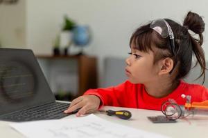 Asia students learn at home in coding robot cars and electronic board cables in STEM, STEAM, mathematics engineering science technology computer code in robotics for kids concept. photo