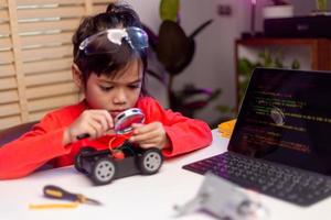 Asia students learn at home in coding robot cars and electronic board cables in STEM, STEAM, mathematics engineering science technology computer code in robotics for kids concept. photo