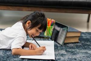 Portrait of preschool kid using tablet for his homework,Soft focus of Child doing homework by using digital tablet searching information on internet,E-learning or Home schooling education concept photo