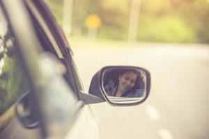 hermosa chica sonríe mientras conduce un coche.color vintage foto