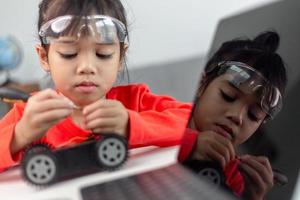 Asia students learn at home in coding robot cars and electronic board cables in STEM, STEAM, mathematics engineering science technology computer code in robotics for kids concept. photo