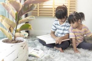 Concentrated siblings reading a book photo