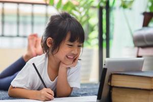 Portrait of preschool kid using tablet for his homework,Soft focus of Child doing homework by using digital tablet searching information on internet,E-learning or Home schooling education concept photo