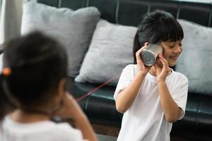 kids playing with tin can and string phone as communication concept photo