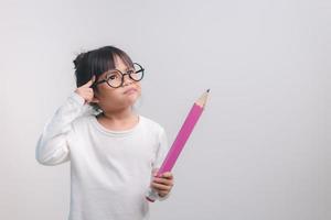 Excited young girl kid holding up big pencils in her hands.Back to school. photo