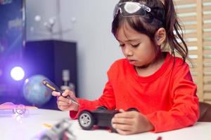 Asia students learn at home in coding robot cars and electronic board cables in STEM, STEAM, mathematics engineering science technology computer code in robotics for kids concept. photo