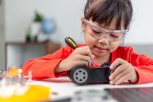 Asia students learn at home in coding robot cars and electronic board cables in STEM, STEAM, mathematics engineering science technology computer code in robotics for kids concept. photo