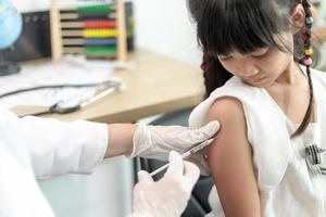 Vacunación exitosa de covid-19. linda niña mientras se inmuniza contra el coronavirus foto