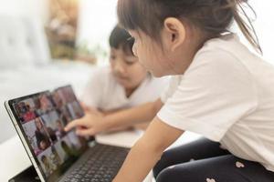 bonita colegiala estudiando la tarea durante su lección en línea en casa, distancia social durante la cuarentena, autoaislamiento, concepto de educación en línea, educadora en casa foto