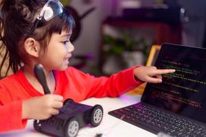 Asia students learn at home in coding robot cars and electronic board cables in STEM, STEAM, mathematics engineering science technology computer code in robotics for kids concept. photo