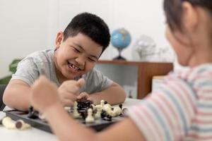 Little boy and little girl are playing chess at home.Children playing chess photo