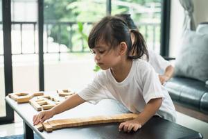 Two happy siblings playing a game with wooden blocks at home joyfully photo