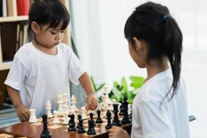 dos lindos niños jugando al ajedrez en casa foto