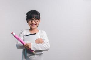 Excited young girl kid holding up big pencils in her hands.Back to school. photo