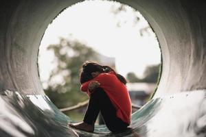 A lonely Asian girl sit alone in the park, Sad thai girl thinks something, sad girl concept photo