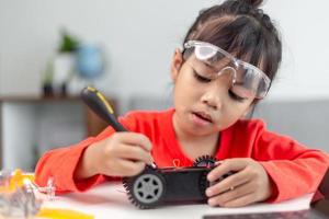 los estudiantes de asia aprenden en casa a codificar autos robot y cables de tableros electrónicos en tallo, vapor, ingeniería matemática, ciencia, tecnología, código de computadora en robótica para el concepto de niños. foto