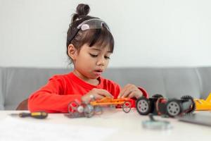 Asia students learn at home in coding robot cars and electronic board cables in STEM, STEAM, mathematics engineering science technology computer code in robotics for kids concept. photo