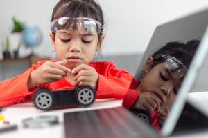Asia students learn at home in coding robot cars and electronic board cables in STEM, STEAM, mathematics engineering science technology computer code in robotics for kids concept. photo