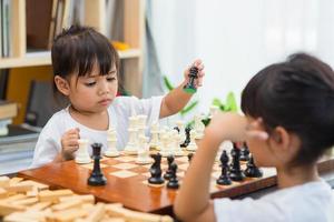 Two cute children playing chess at home photo