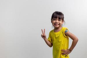 COVID 19 Vaccines for Kids concept. Studio a portrait of an adorable Asian girl after getting his first dose of vaccine. Immune, Safe, Available, Back to school. photo