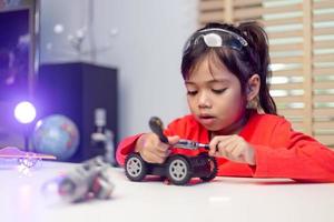 Asia students learn at home in coding robot cars and electronic board cables in STEM, STEAM, mathematics engineering science technology computer code in robotics for kids concept. photo