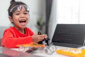 los estudiantes de asia aprenden en casa a codificar autos robot y cables de tableros electrónicos en tallo, vapor, ingeniería matemática, ciencia, tecnología, código de computadora en robótica para el concepto de niños. foto