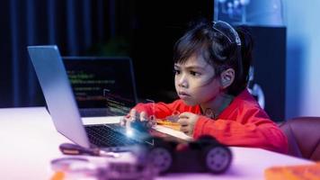 los estudiantes de asia aprenden en casa a codificar autos robot y cables de tableros electrónicos en tallo, vapor, ingeniería matemática, ciencia, tecnología, código de computadora en robótica para el concepto de niños. foto