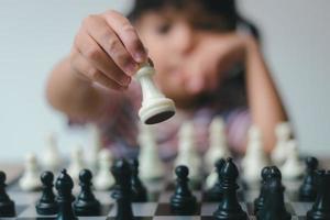 Asian little girl playing chess at home.a game of chess photo