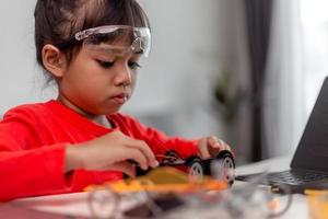 Asia students learn at home in coding robot cars and electronic board cables in STEM, STEAM, mathematics engineering science technology computer code in robotics for kids concept. photo