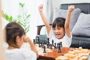 Kids playing chess - one of them just captured a pawn and celebrates photo