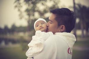 father is kissing his cute little girl in forehead photo