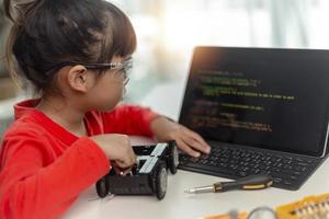 los estudiantes de asia aprenden en casa a codificar autos robot y cables de tableros electrónicos en tallo, vapor, ingeniería matemática, ciencia, tecnología, código de computadora en robótica para el concepto de niños. foto