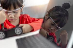 los estudiantes de asia aprenden en casa a codificar autos robot y cables de tableros electrónicos en tallo, vapor, ingeniería matemática, ciencia, tecnología, código de computadora en robótica para el concepto de niños. foto