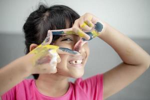 educación, escuela, arte y concepto de pintura - niña estudiante mostrando manos pintadas foto