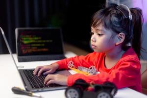 los estudiantes de asia aprenden en casa a codificar autos robot y cables de tableros electrónicos en tallo, vapor, ingeniería matemática, ciencia, tecnología, código de computadora en robótica para el concepto de niños. foto