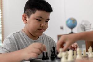 Little boy and little girl are playing chess at home.Children playing chess photo