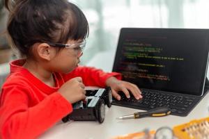 los estudiantes de asia aprenden en casa a codificar autos robot y cables de tableros electrónicos en tallo, vapor, ingeniería matemática, ciencia, tecnología, código de computadora en robótica para el concepto de niños. foto