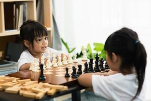 Two cute children playing chess at home photo