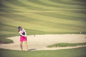 Golfers hit the ball in the sand. Speed and Strength.Vintage color photo